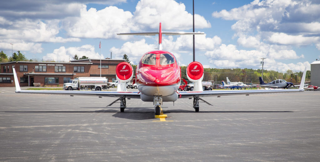 photo of red and white jet sitting on runway